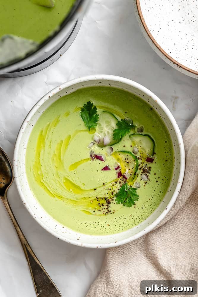 Cool Cucumber Delight 2 A bowl of creamy, green Cucumber Gazpacho garnished with fresh herbs and a drizzle of olive oil, ready to be enjoyed.