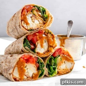 Completed BBQ or Buffalo Cauliflower Veggie Wraps stacked on one another against a white background, highlighting a quick, delicious, and healthy plant-based meal.
