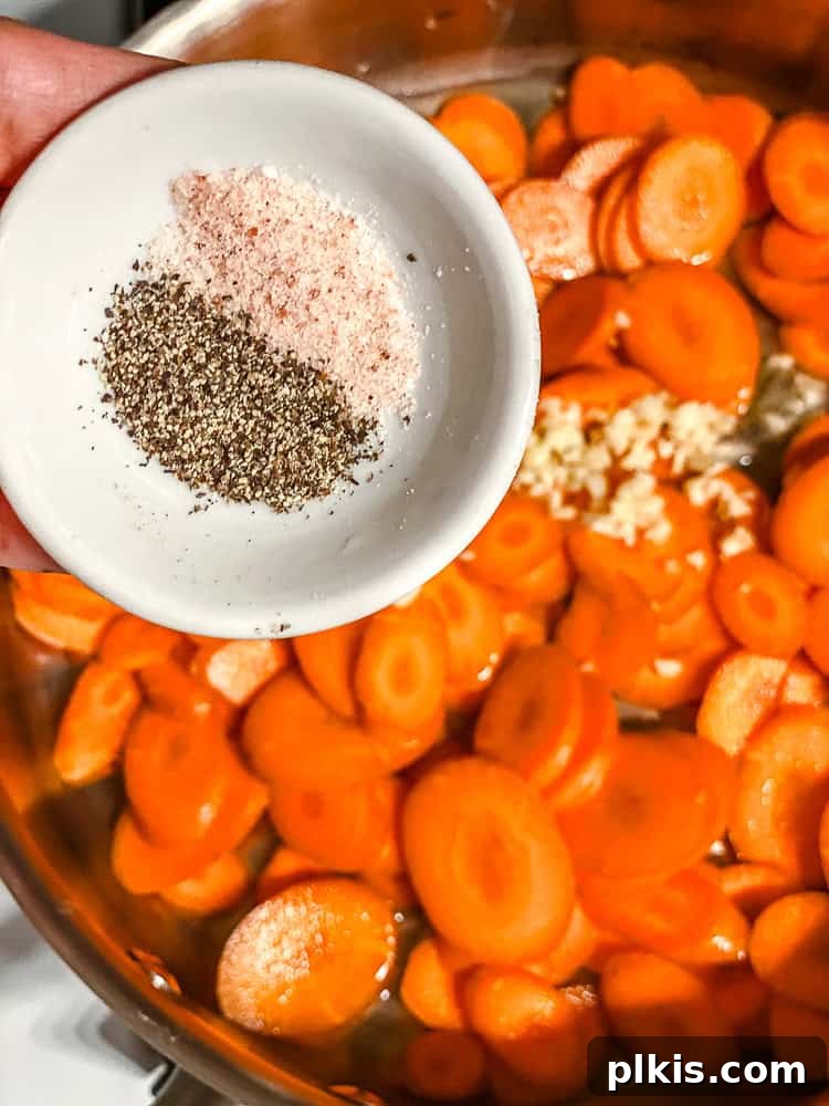 Golden Glazed Carrots 5 Process shot of salt and pepper being sprinkled over carrots in a pan.