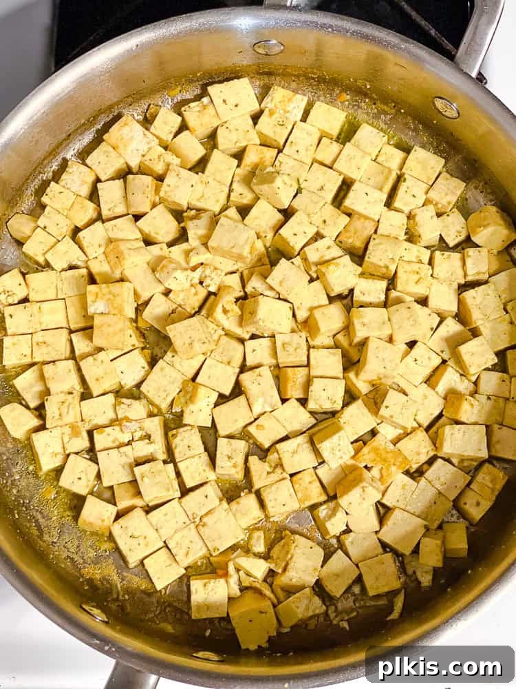 process shot showing tofu browning in pan after stock has evaporated