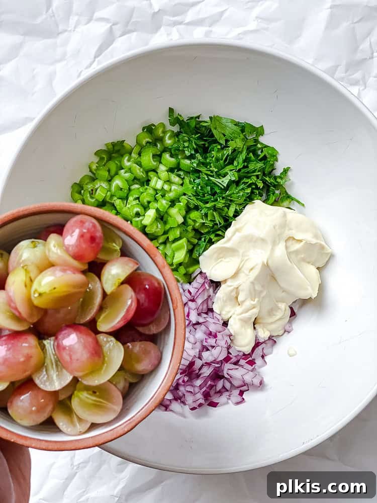 process shot showing adding grapes and other fresh ingredients to a mixing bowl