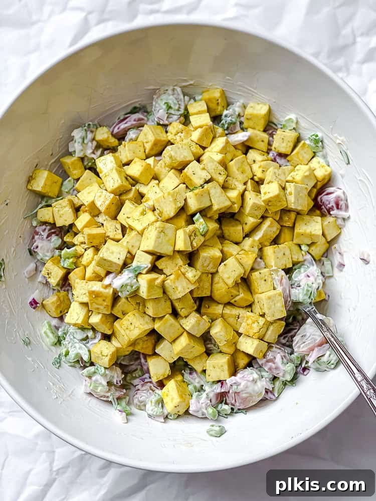 process shot of adding cooled tofu to the mixed salad ingredients