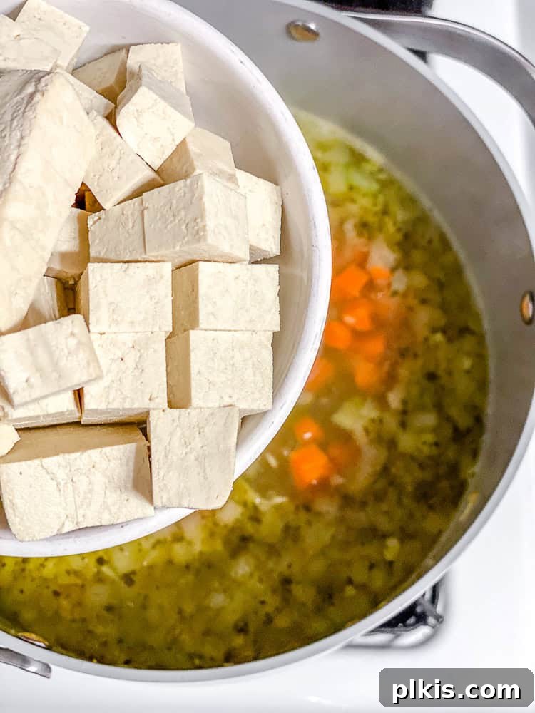 Sunshine Lemon Orzo Soup 5 Process shot showing diced tofu being added to the pot with sautéed vegetables, before the broth is added.