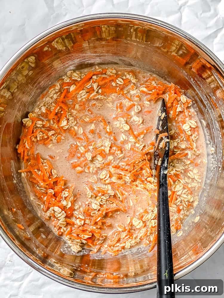 Warm Spiced Carrot Cake Baked Oats 5 A process shot demonstrating the wet ingredients being combined with the dry ingredients for Carrot Cake Baked Oats, creating a uniform batter.