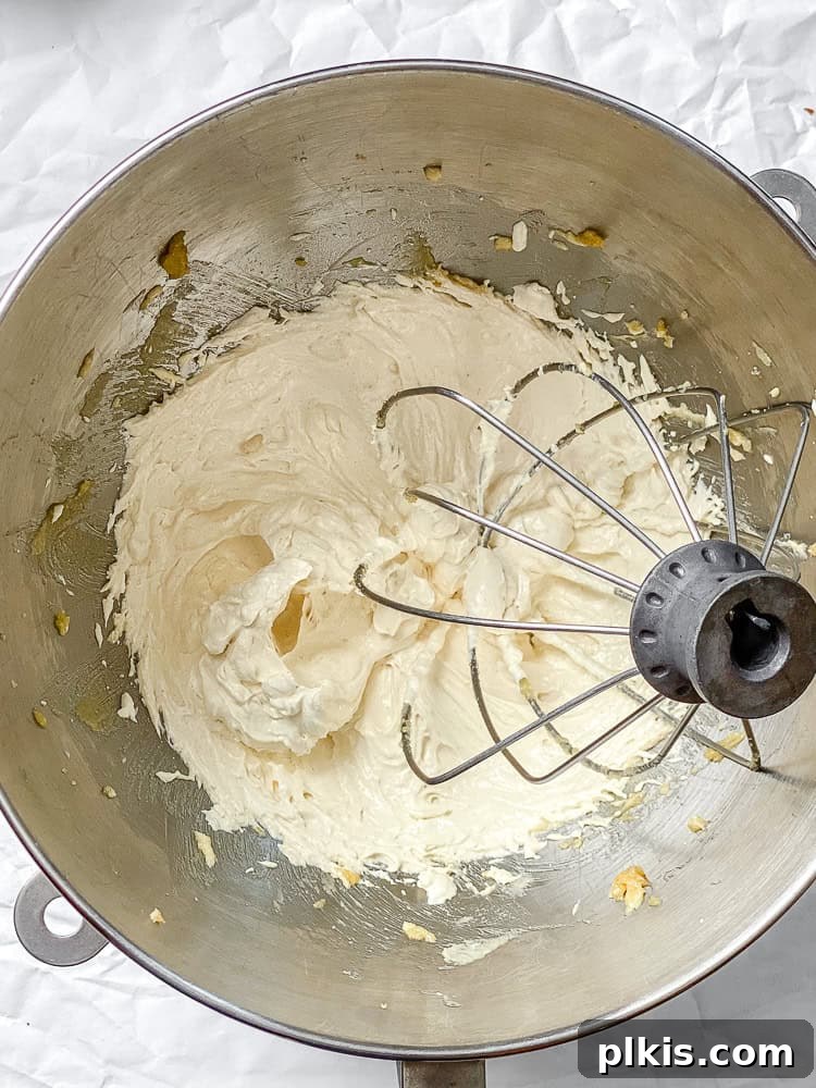 Spiced Apple Pie Cookies 5 Process shot showing vegan butter and brown sugar being whisked together in a large mixing bowl, creating a light, creamy texture.