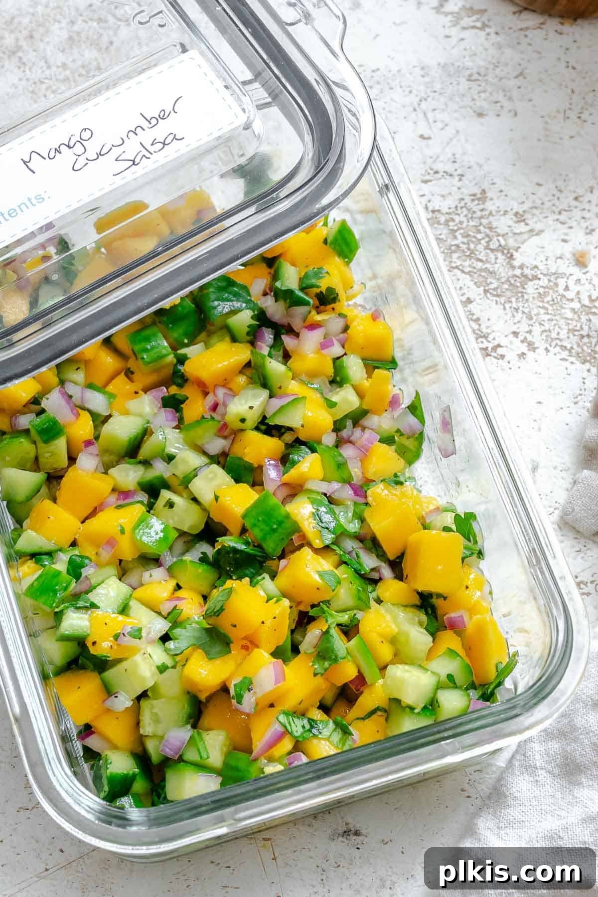 Sunshine Mango Cucumber Salsa 7 Completed Mango Cucumber Salsa in a clear storage container, ready to be refrigerated.