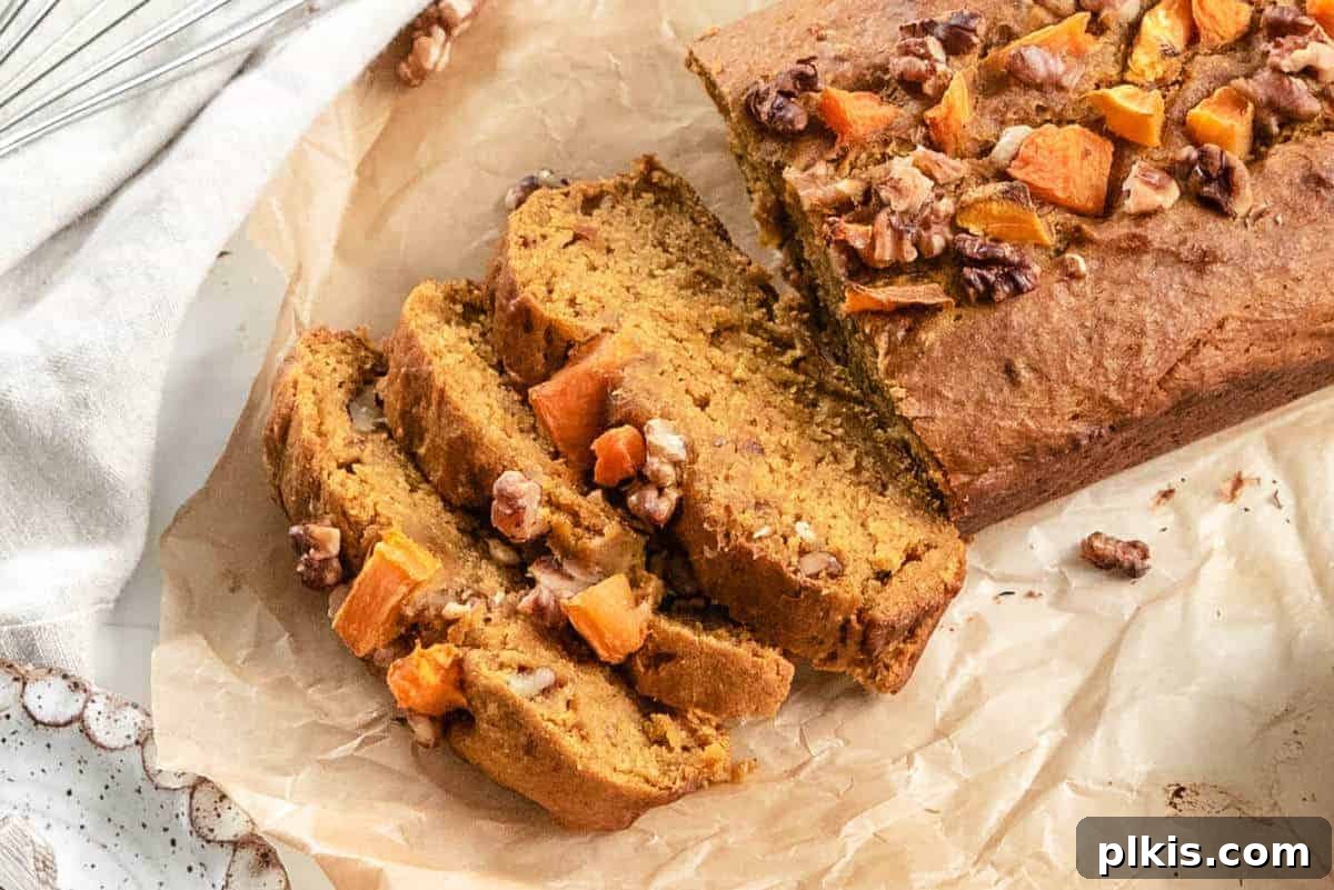 Sliced vegan pumpkin bread on parchment paper, moist and inviting