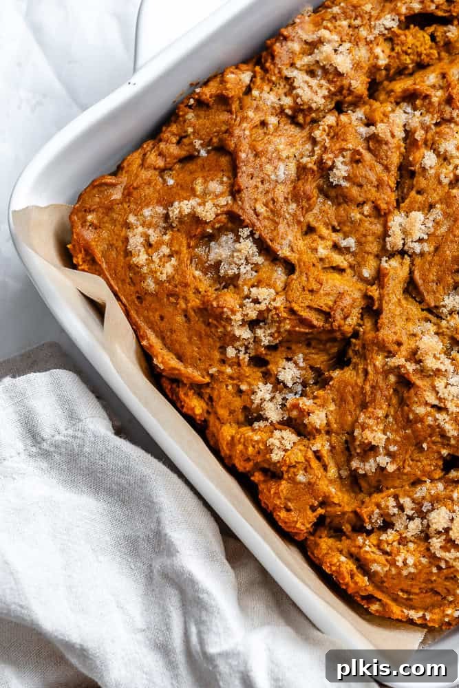 Pumpkin Spice Streusel Coffee Cake 8 A freshly baked vegan Pumpkin Coffee Cake with streusel topping, cooling in its white ceramic baking dish, ready for slicing.