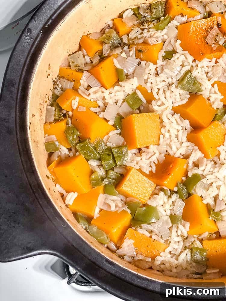 Close-up process shot of the Easy Pumpkin Rice in the pot, just after cooking and resting, showing fluffy rice and tender pumpkin.
