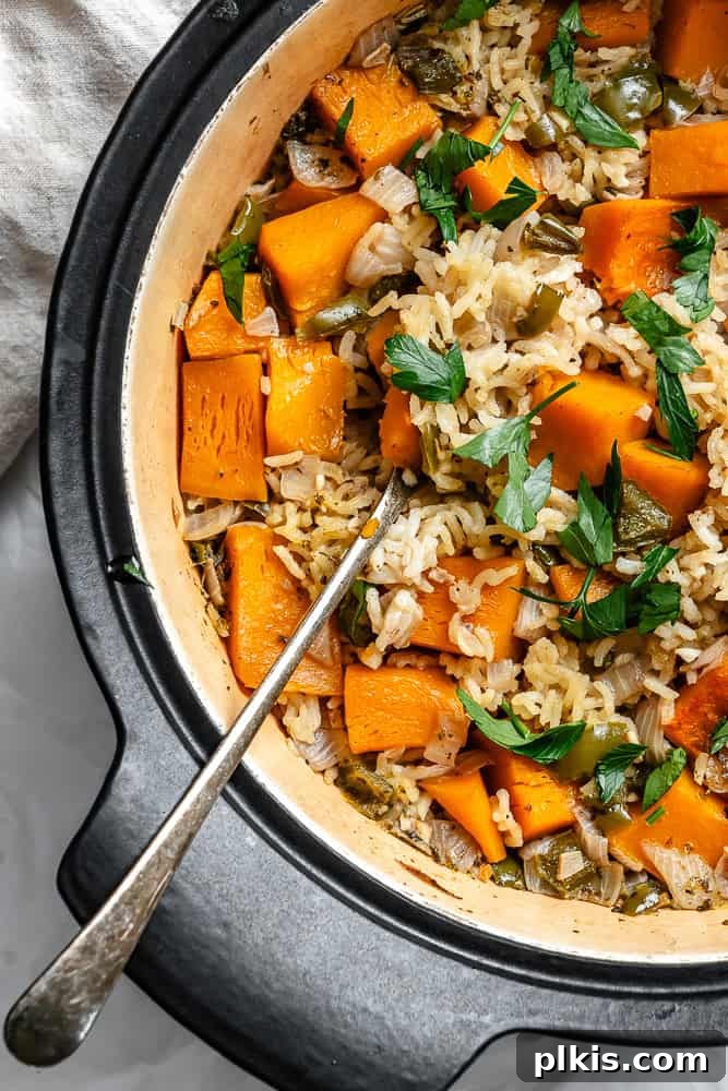 A close-up of the completed Easy Pumpkin Rice in a large pot, showing the creamy texture, vibrant pumpkin pieces, and fluffy rice grains.