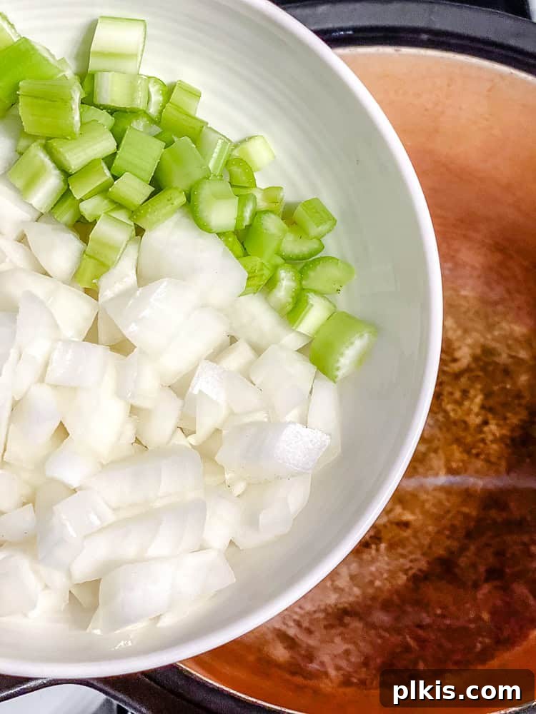 Creamy Plant-Based White Bean Chili 5 process shot showing veggies being added to pan