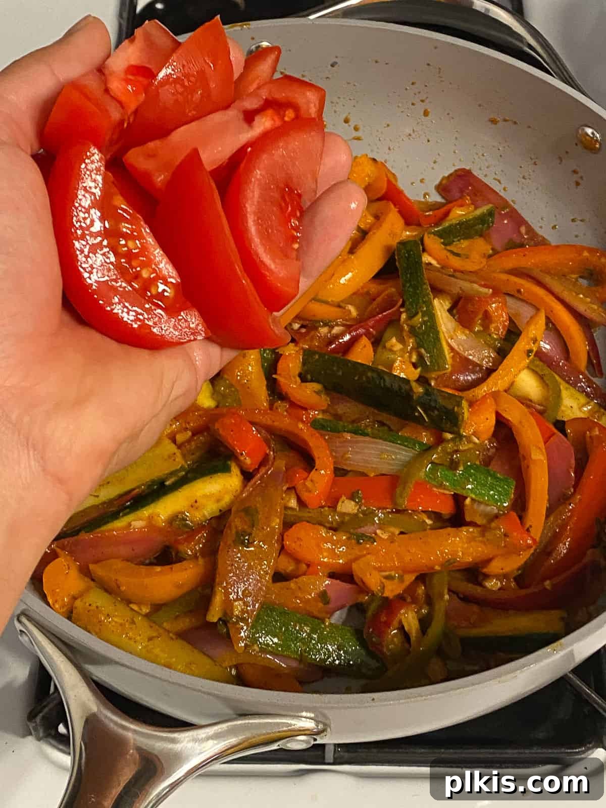 Sizzling Plant-Powered Fajitas 10 process shot of adding red bell pepper to pan of veggies