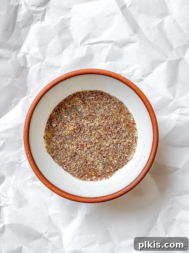Cozy Gingerbread Oatmeal Cookies 4 Process shot illustrating flax meal and warm water being combined in a bowl, forming a vegan egg.