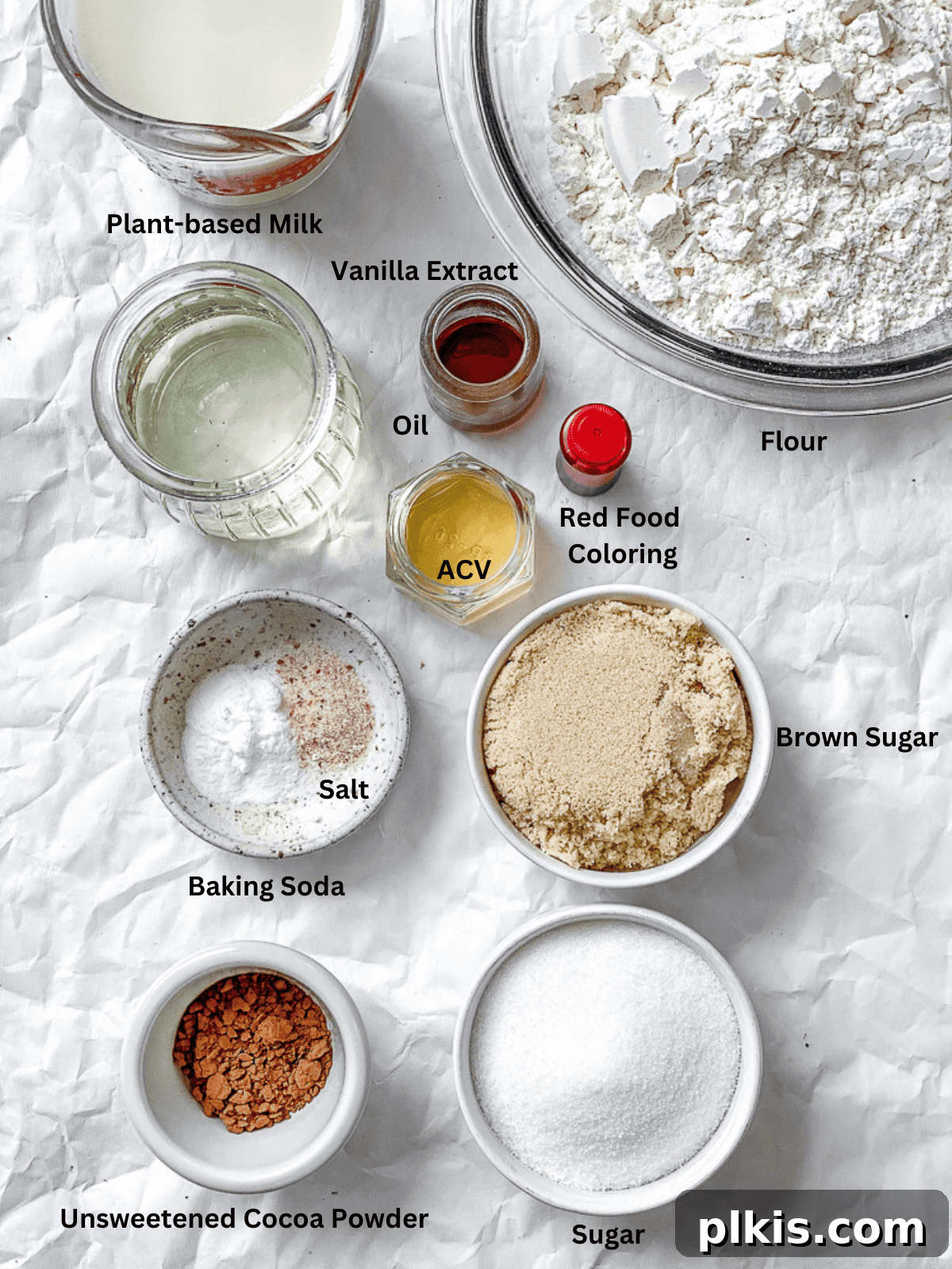 Plant-Based Red Velvet Perfection 3 All the necessary ingredients for Vegan Red Velvet Cake carefully measured out in separate bowls, arranged neatly on a white surface.