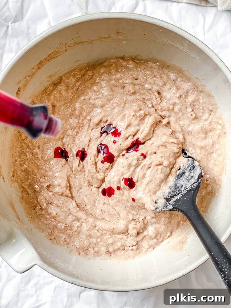 Plant-Based Red Velvet Perfection 5 Process shot showing the wet ingredients for Vegan Red Velvet Cake being whisked together in a large mixing bowl.