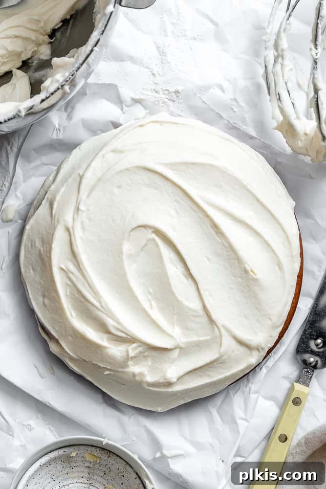 Plant-Based Red Velvet Perfection 7 A beautifully sliced piece of vegan red velvet cake, revealing its moist red layers and creamy white frosting, on a white plate with the full cake in the background.