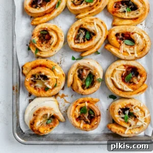 several completed vegan pizza rolls on a baking dish
