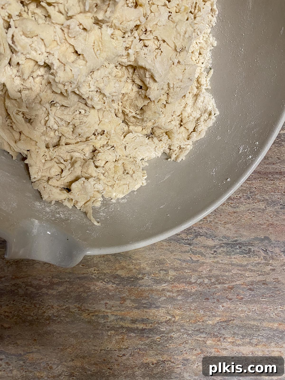 The process of mixing and forming the pizza dough in a white bowl, showing the consistency as ingredients come together.
