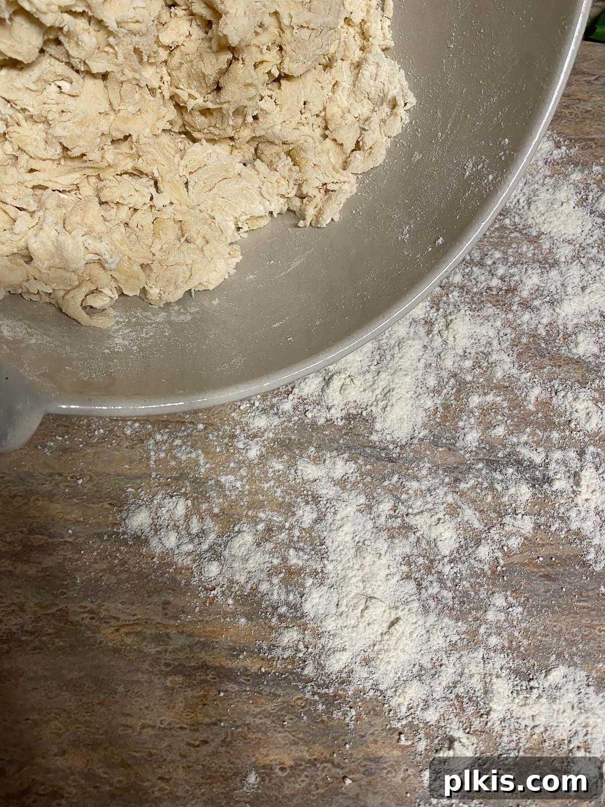 Hands expertly kneading the pizza dough on a floured surface until it becomes smooth and elastic.