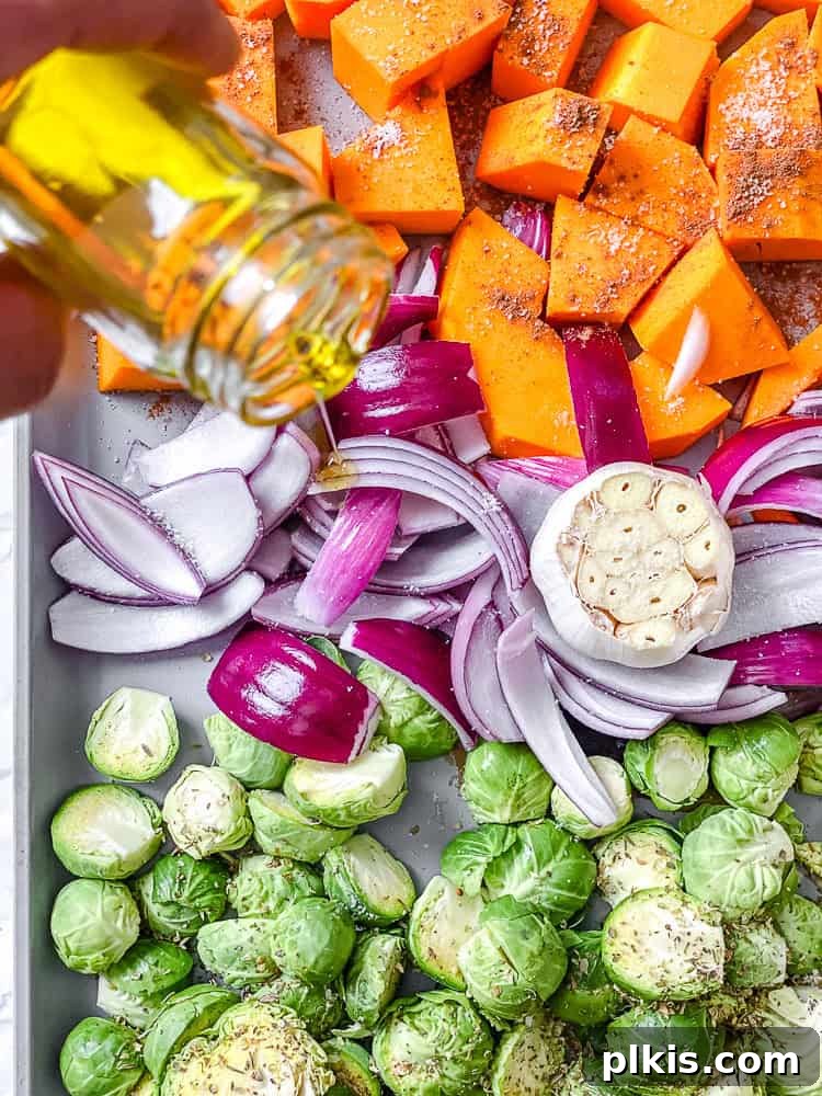 Golden Harvest Quinoa Salad 5 Process shot of drizzling olive oil over the vegetables on a baking sheet before roasting.