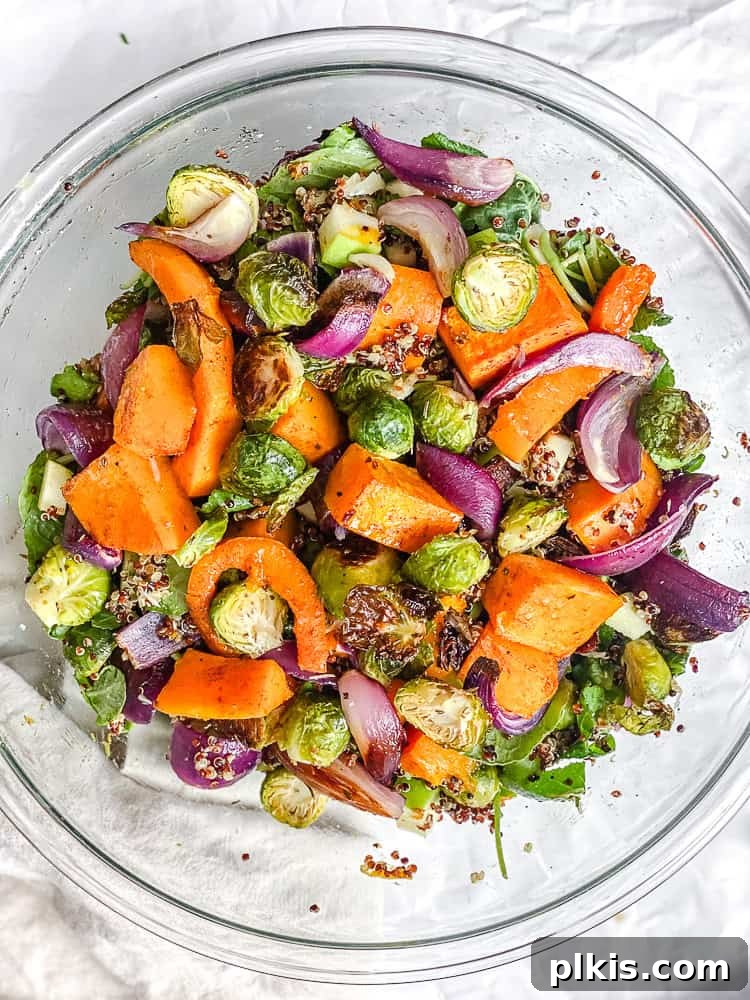 Golden Harvest Quinoa Salad 9 Process shot showing the assembly of the salad with quinoa, kale, and roasted vegetables in a large bowl.