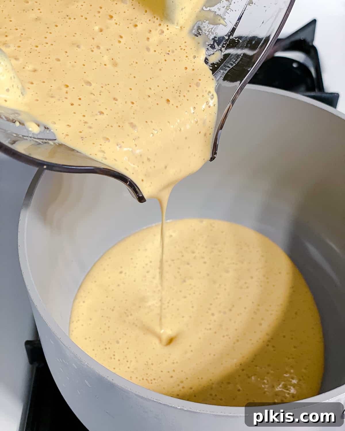 Simple Plant-Based Hollandaise 5 process shot of adding blended ingredients to pot
