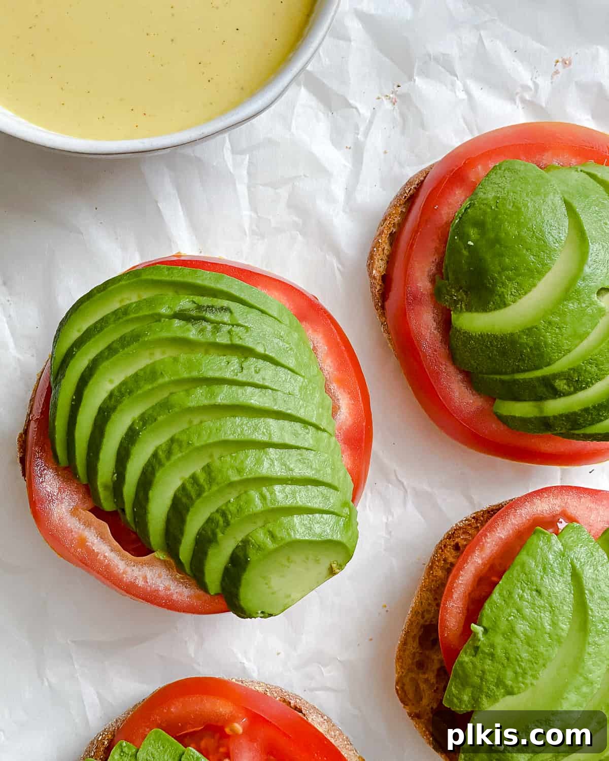 Simple Plant-Based Hollandaise 6 process shot of adding tomato and avocado slices to sandwich
