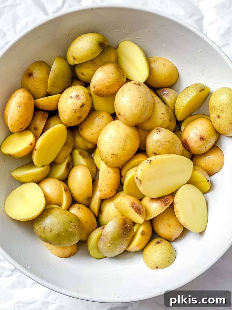 Rosemary Garlic Roasted Baby Potatoes 4 Process shot showing halved baby potatoes in a mixing bowl, ready for seasoning.
