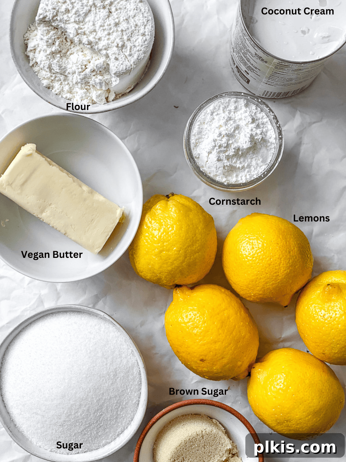 Sunshine Vegan Lemon Squares 3 ingredients for Easy Vegan Lemon Bars on a white surface, including lemons, coconut cream, vegan butter, and flour