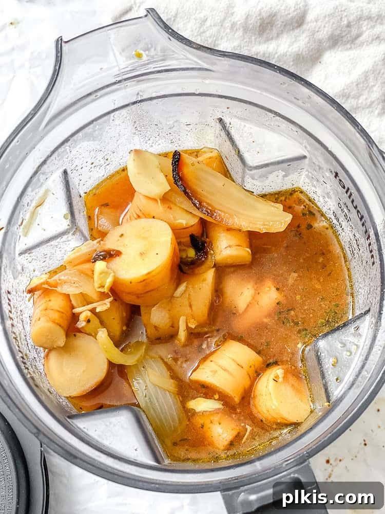 Maple-Kissed Roasted Parsnip Soup 6 Ingredients for Roasted Parsnip Soup being blended in a high-speed blender.