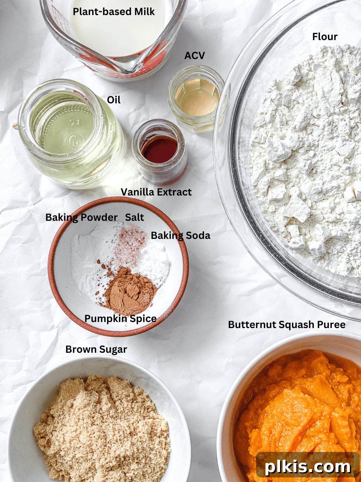 Spiced Butternut Delight 3 All ingredients for Butternut Squash Cake neatly measured out in bowls and cups on a pristine white surface, ready for mixing.