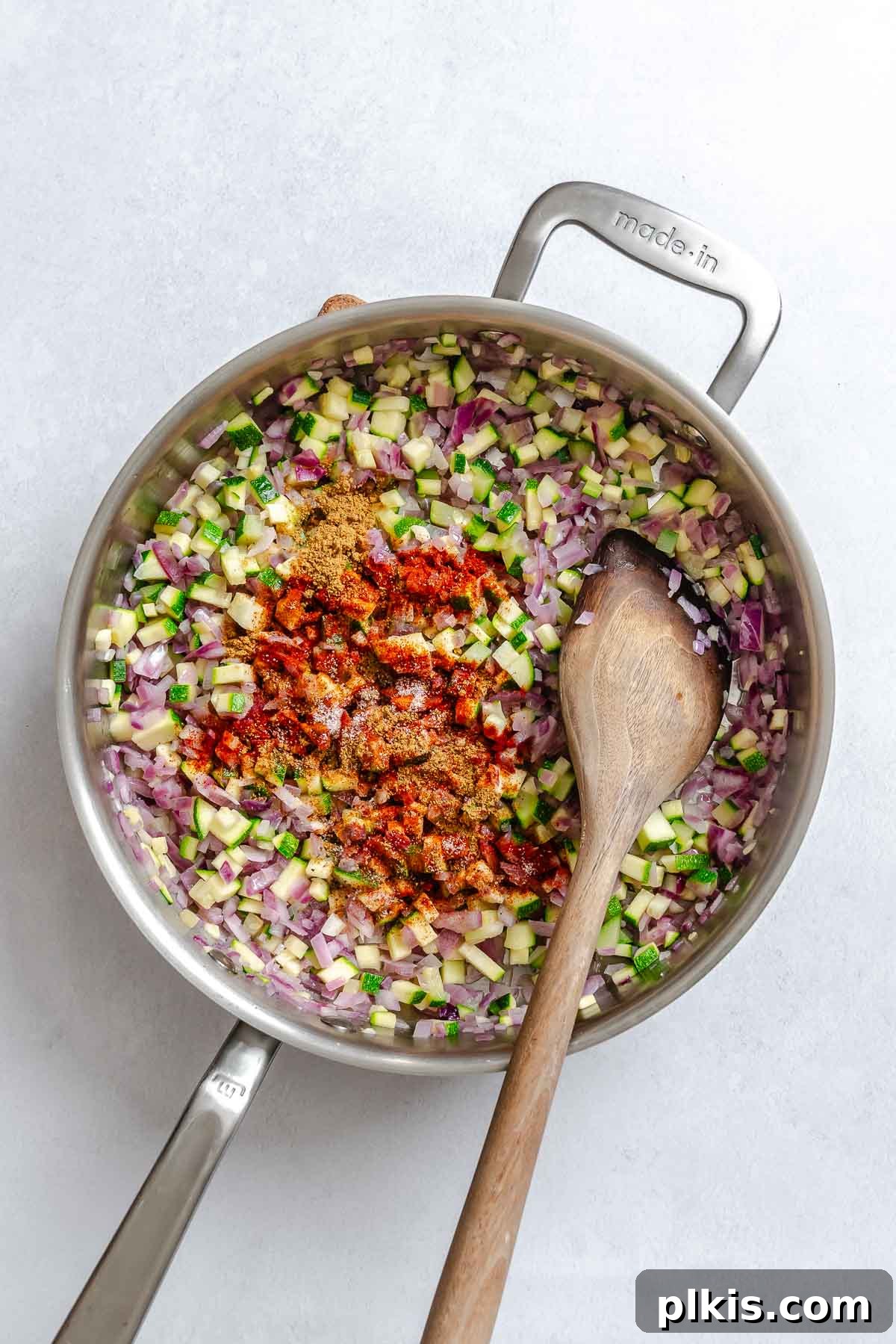 Wholesome Quinoa Stuffed Peppers 6 Process shot showing stirring ingredients in pot.