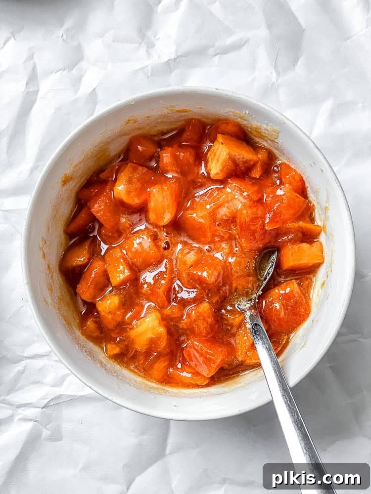 Simple Spiced Persimmon Muffins 4 A process shot showing diced Fuyu persimmons being gently mixed with sugar in a bowl, preparing them for the muffin batter.