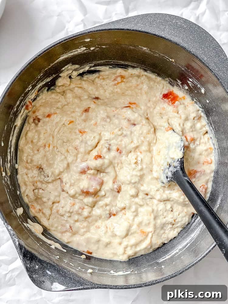 Simple Spiced Persimmon Muffins 5 A process shot showing wet ingredients, including plant milk and applesauce, being stirred together in a large bowl, ready for the dry ingredients.