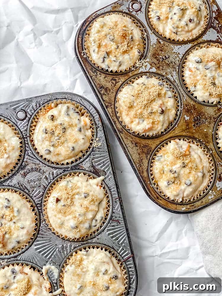 Simple Spiced Persimmon Muffins 7 A process shot showing muffin batter, sprinkled with brown sugar, neatly scooped into muffin liners in a baking tin, ready for the oven.