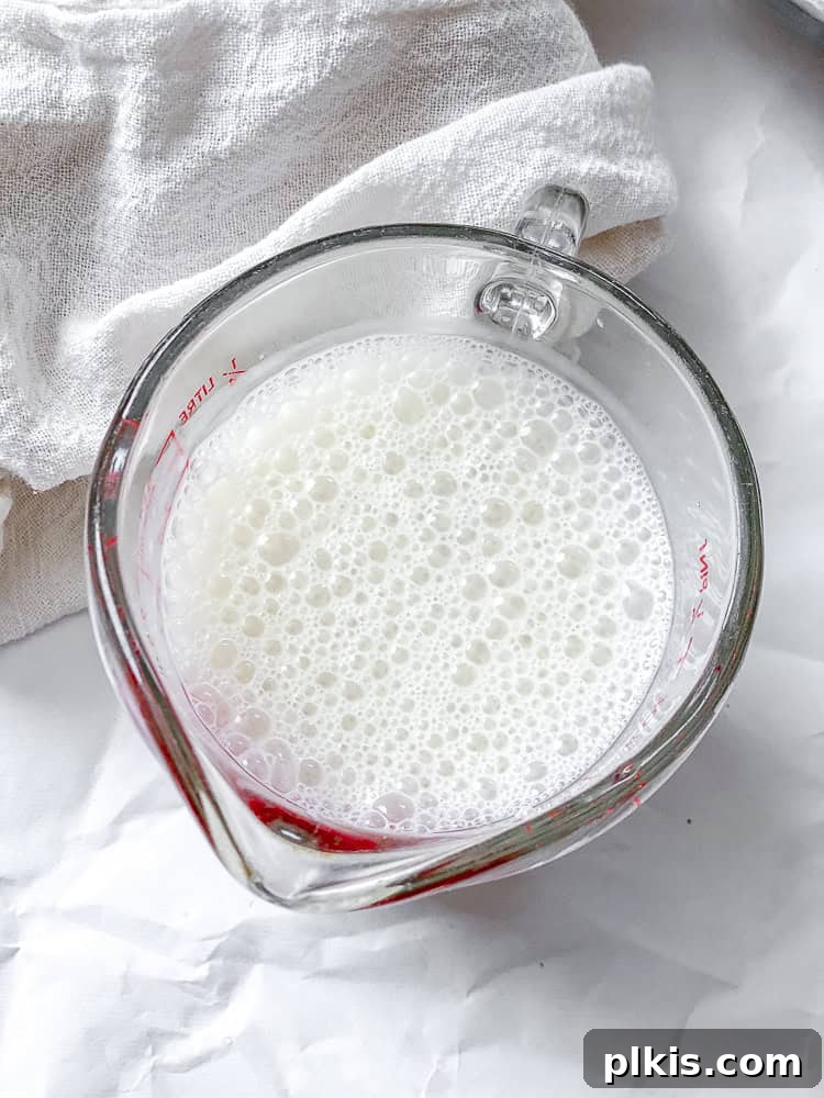 A bowl containing a mixture of plant milk and apple cider vinegar, transforming into vegan buttermilk.