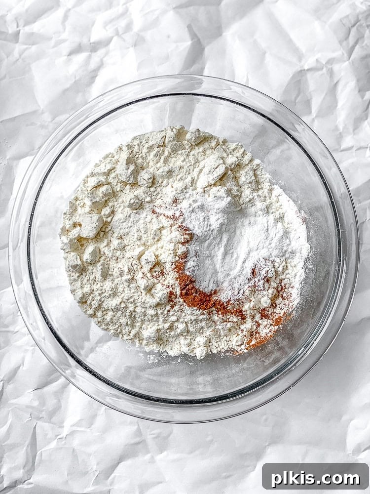 Dry ingredients for butternut squash cupcakes mixed in a bowl, awaiting combination with wet ingredients.