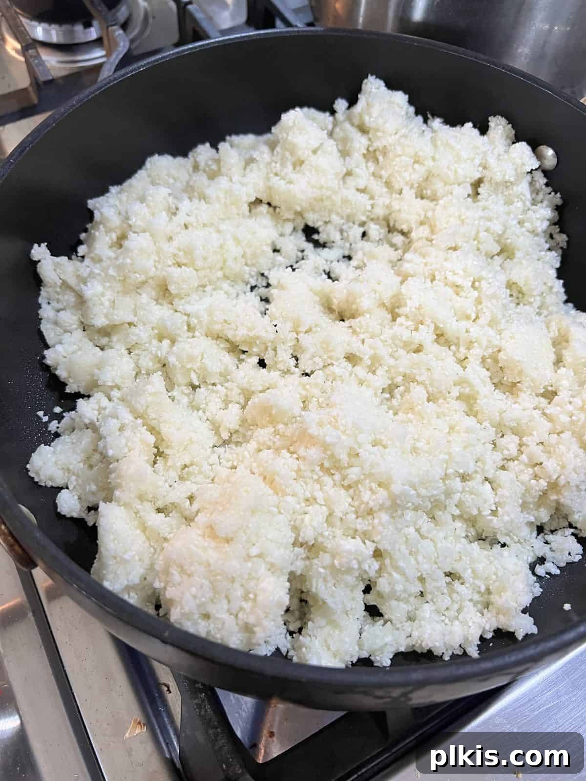 Quick and Flavorful Spanish Cauliflower Rice Bowl with Salsa 7 riced cauliflower in a black pan