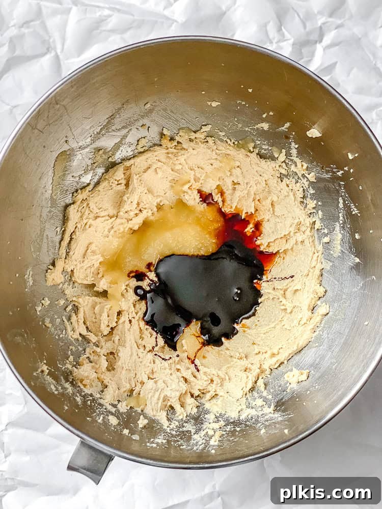 Cozy Vegan Gingerbread Delights 4 Process shot showing wet ingredients like vegan butter, brown sugar, molasses, and applesauce added to a mixing bowl.