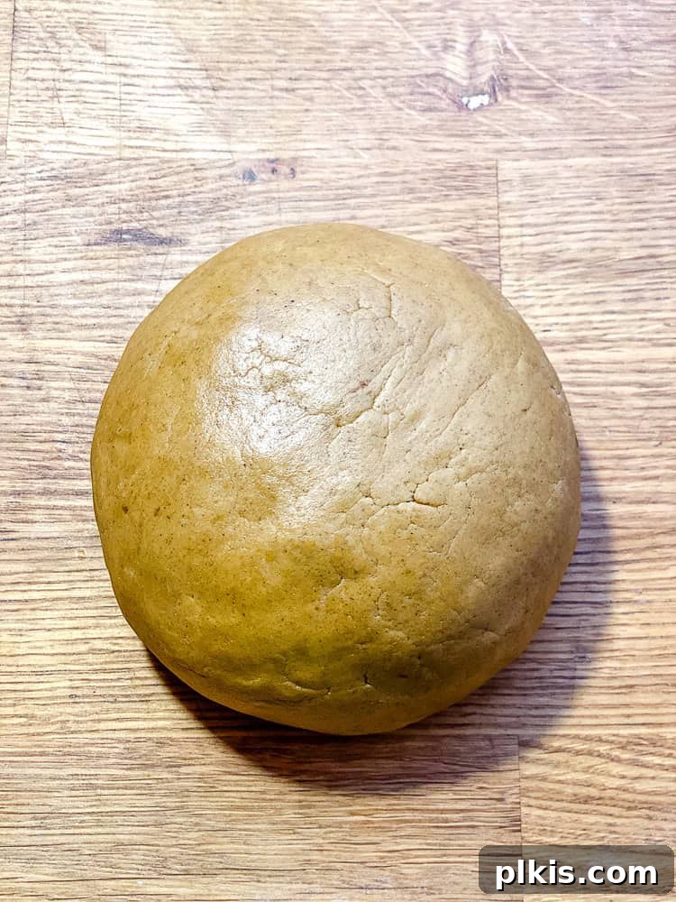 Cozy Vegan Gingerbread Delights 6 Process shot showing the thick gingerbread dough formed into a ball and placed on a surface.