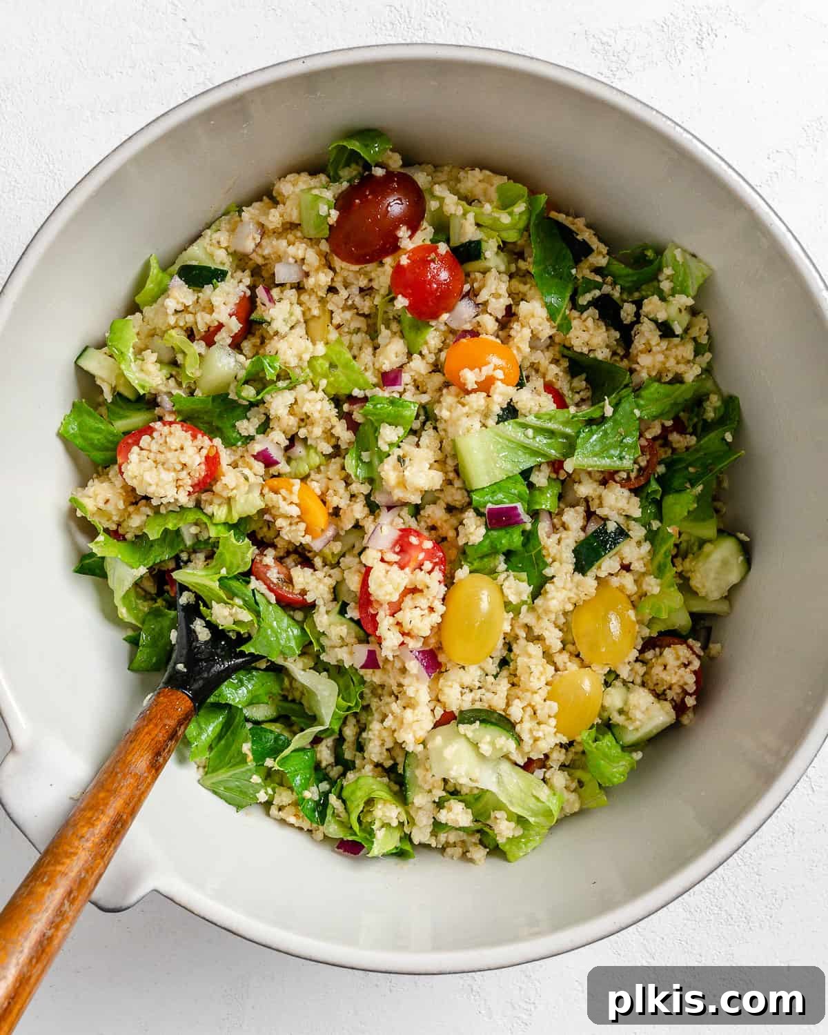 Vibrant Vegan Greek Millet Bowl 14 A vibrant mix of all the ingredients for Vegan Greek Millet Salad, beautifully tossed and combined in a white bowl, ready for chilling.