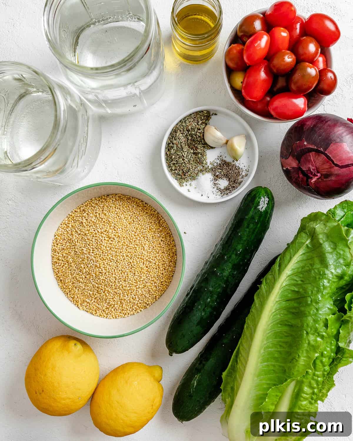 Vibrant Vegan Greek Millet Bowl 3 A selection of fresh ingredients for Vegan Greek Millet Salad, including colorful vegetables, a bowl of millet, and dressing components, neatly measured out against a clean white background.