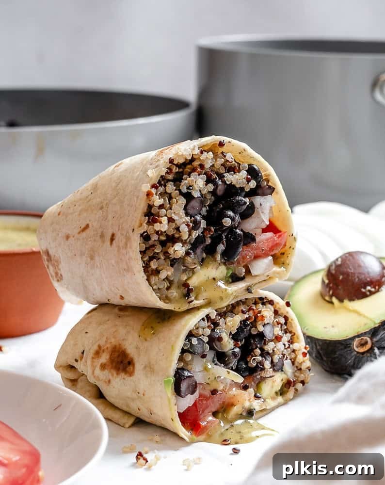 Hearty Quinoa Black Bean Burritos 2 completed Quinoa Black Bean Burritos stacked on one another, showcasing the vibrant filling