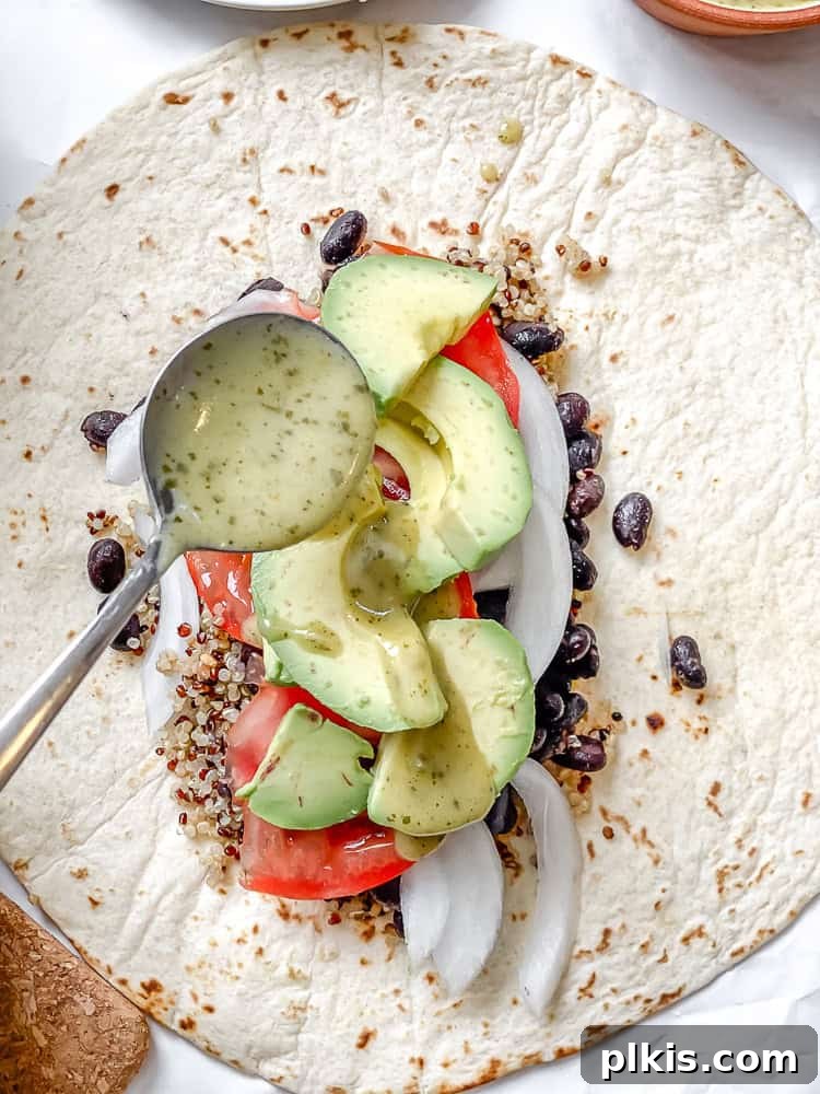Hearty Quinoa Black Bean Burritos 6 process shot showing adding salad dressing to burrito filling on a tortilla
