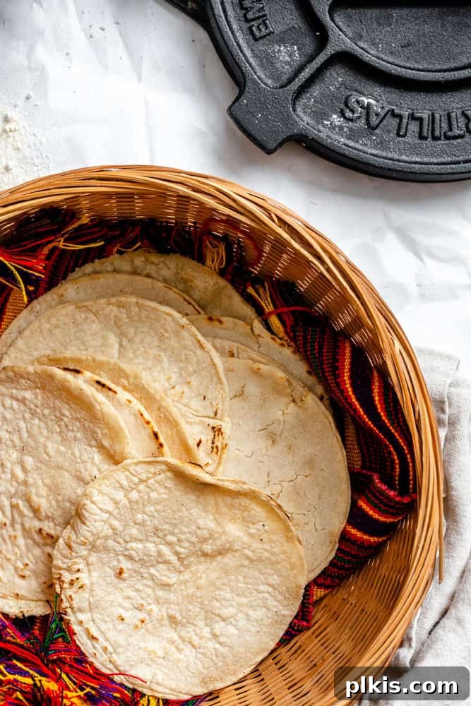 Crafting Perfect Corn Tortillas at Home 8 A charming woven basket overflowing with a stack of freshly made, soft, and warm homemade corn tortillas.