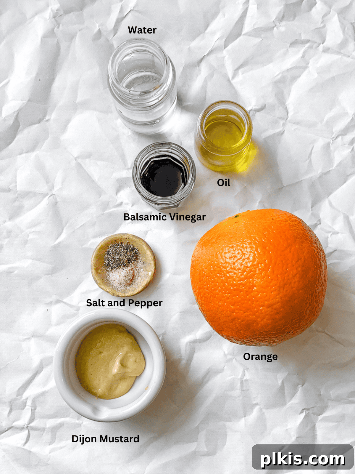 Bright Orange Vinaigrette 3 ingredients for Easy Orange Vinaigrette measured out on a white surface, including oranges, olive oil, balsamic vinegar, mustard, salt, and pepper