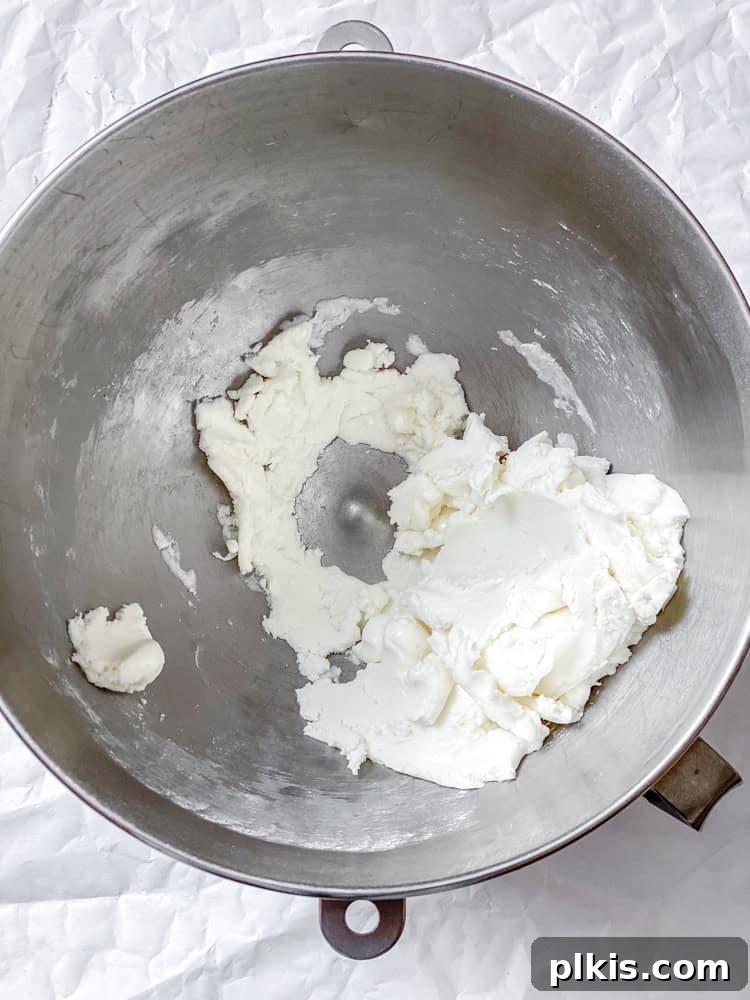 Cool Mint Vegan Delights 4 Process shot showing powdered sugar, plant milk, and peppermint extract being mixed together in a large bowl with an electric mixer.