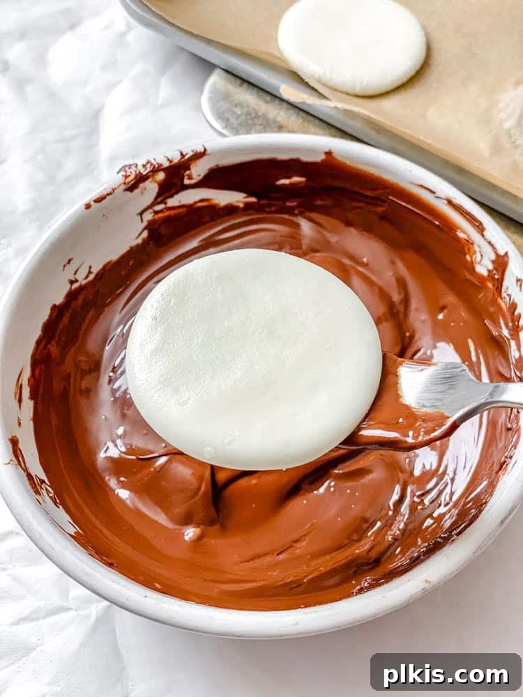 Cool Mint Vegan Delights 6 Process shot showing a vegan peppermint patty being dipped into a bowl of melted vegan chocolate using a fork, with excess chocolate dripping off.