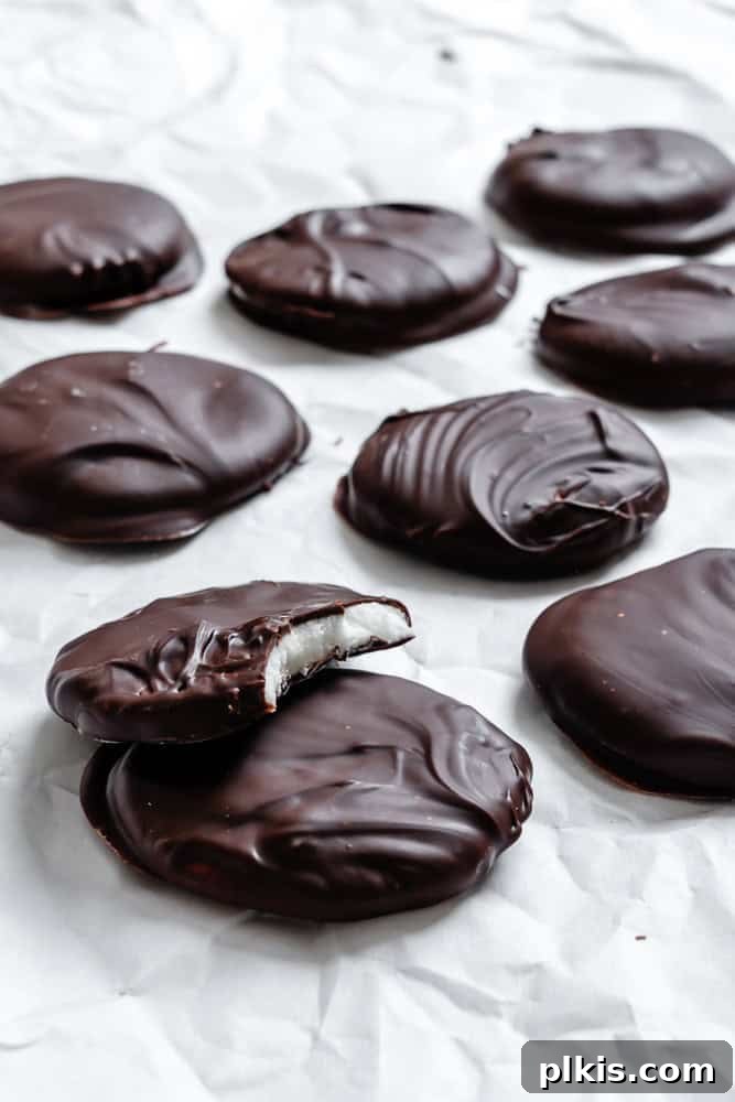 Cool Mint Vegan Delights 8 A close-up of several perfectly formed and chocolate-coated Vegan Peppermint Patties arranged on a white surface, showcasing their smooth texture.