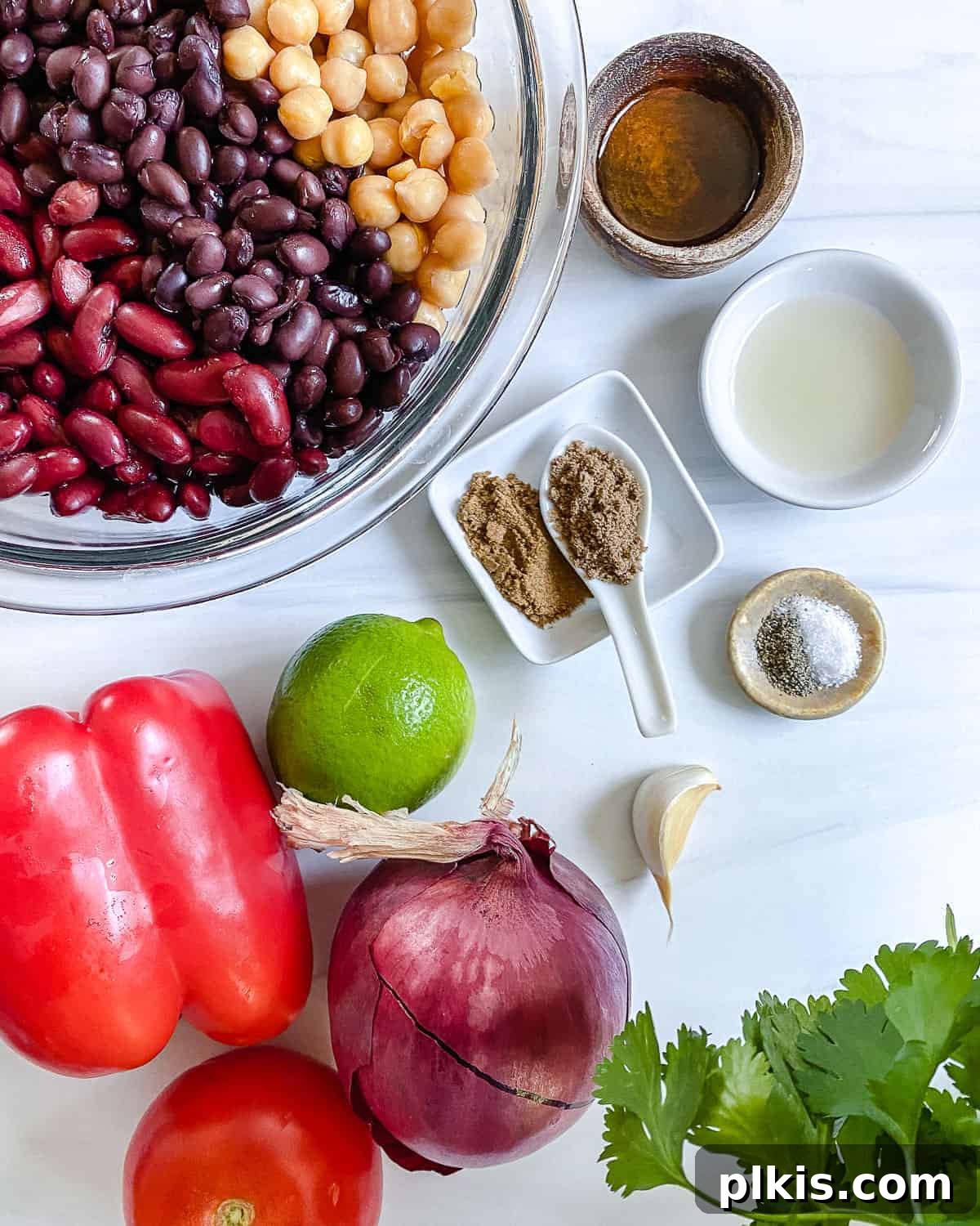 Ingredients for mixed bean salad laid out on a white background.